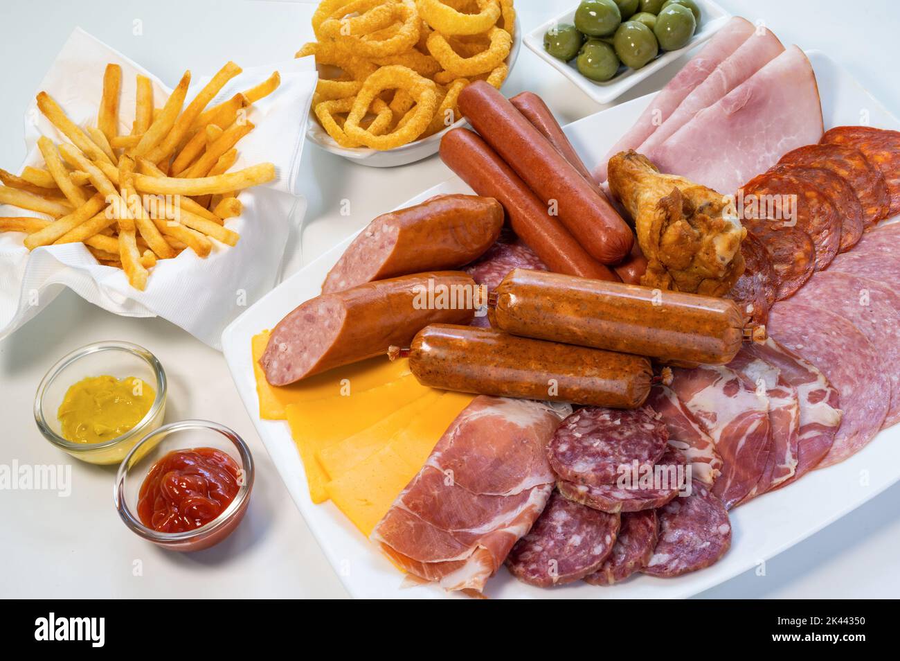Assorted unhealthy processed and fried foods on table Stock Photo