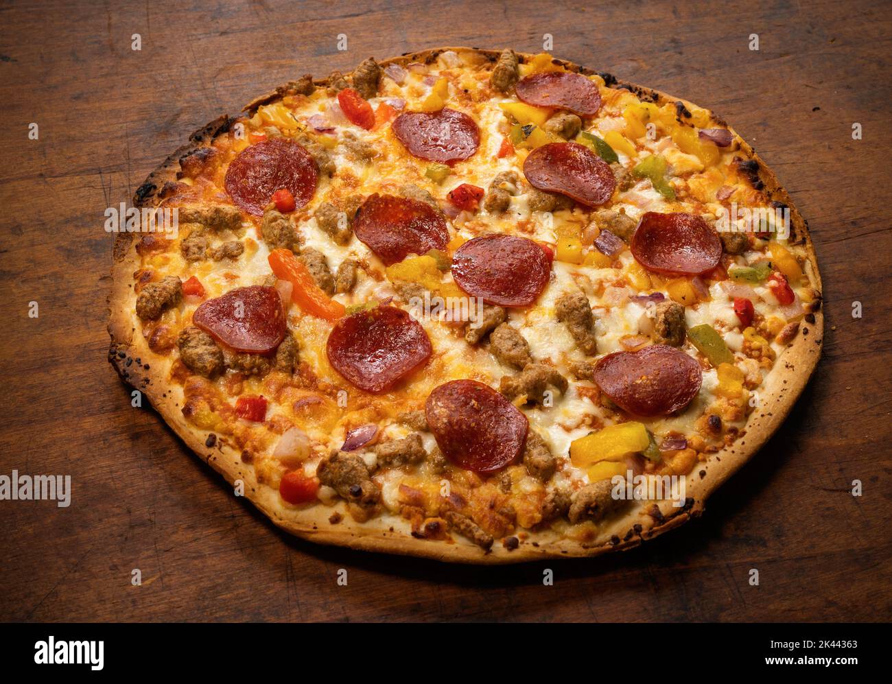 Whole pizza on wooden table Stock Photo