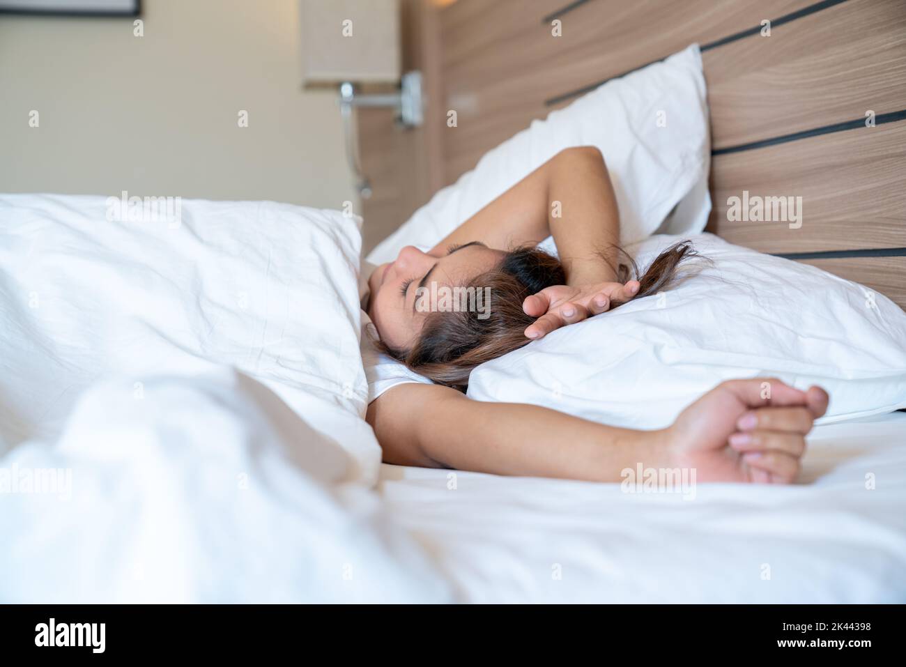 Young asian women stretching and smiling in bed after wake up in the ...