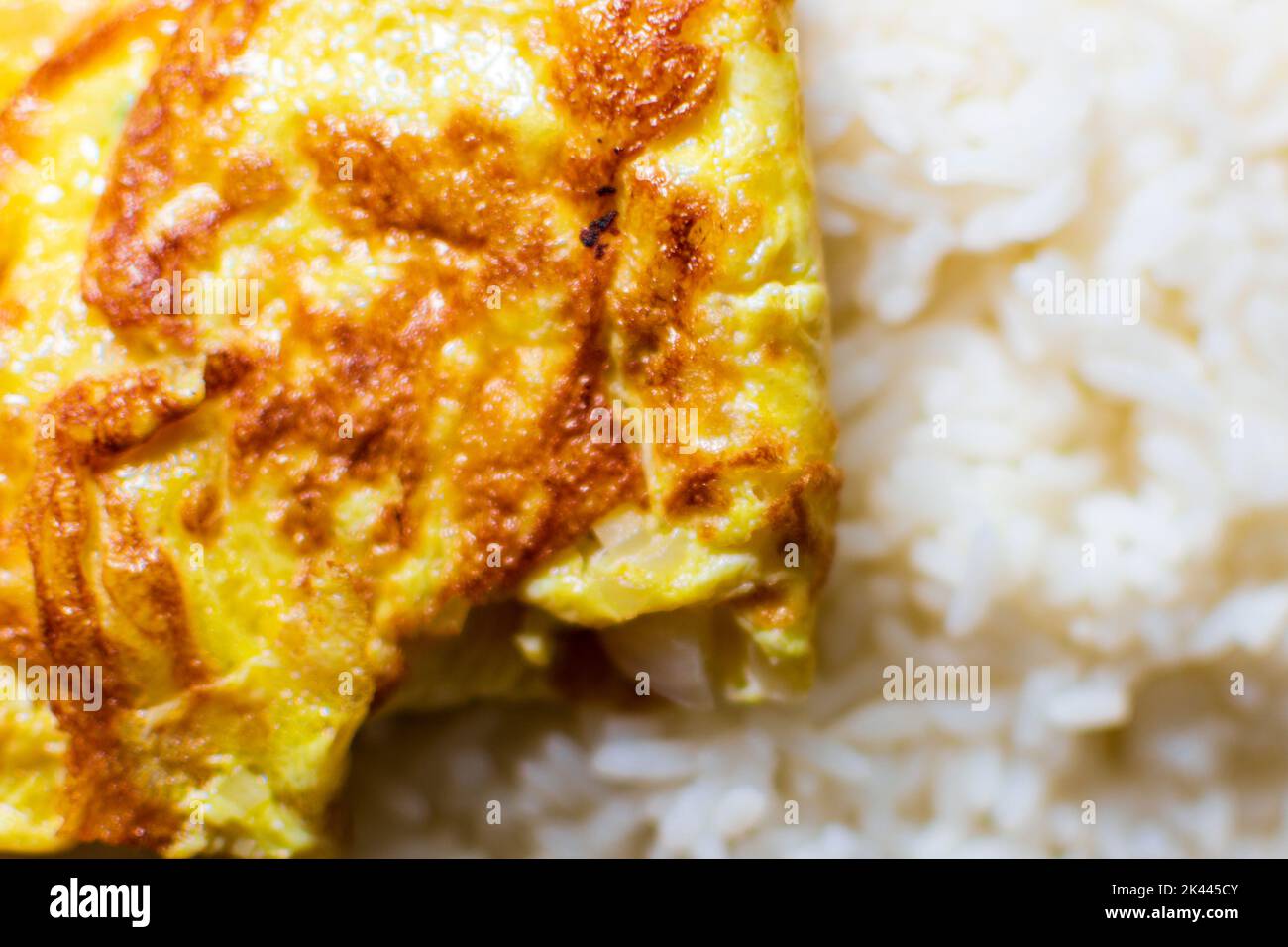 Folded egg omelette kept on the hot rice on a dining plate healthy