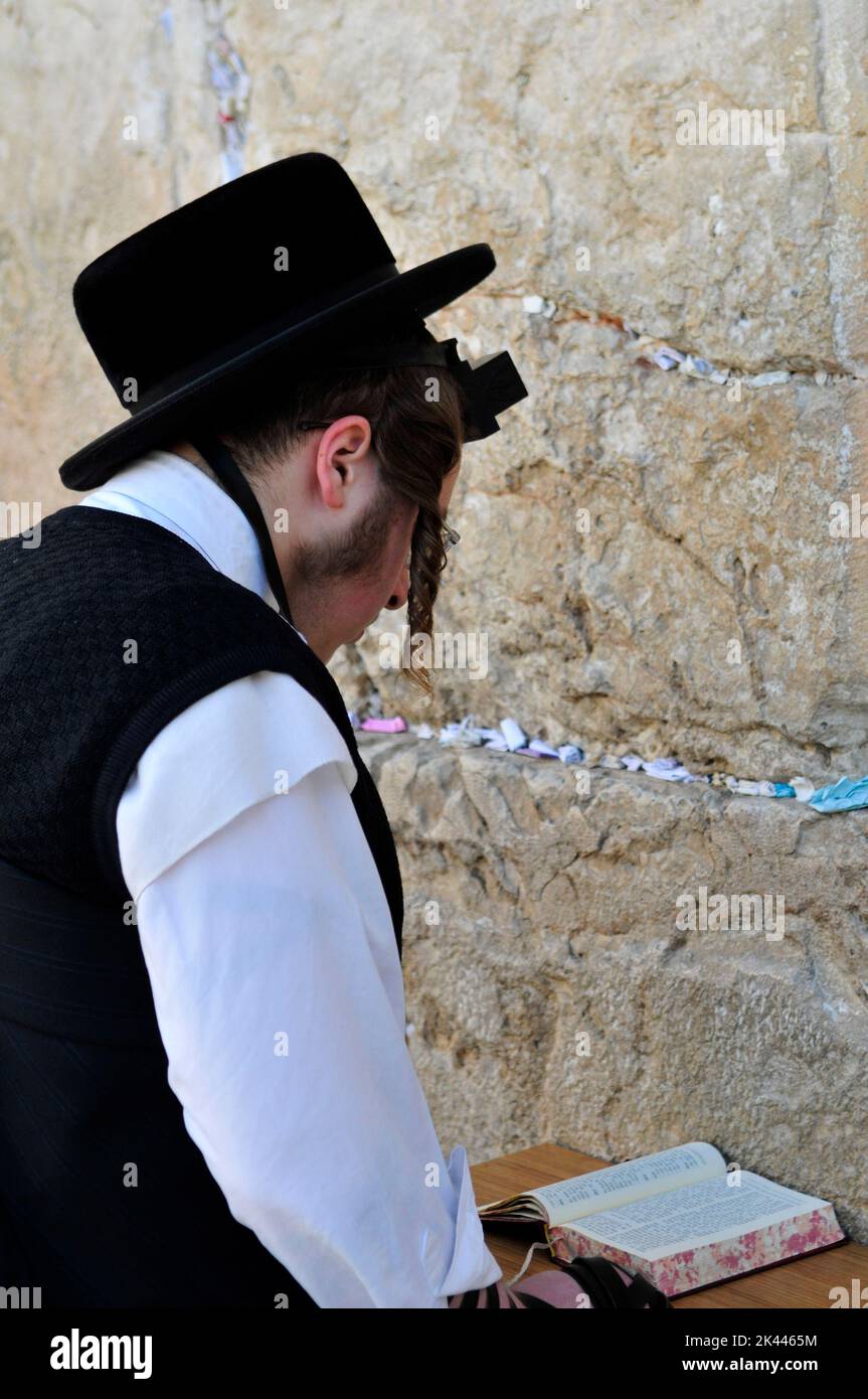 Jewish men praying by the Wailing Wall / Western Wall in the Jewish quarter in the old city of Jerusalem, Israel. Stock Photo