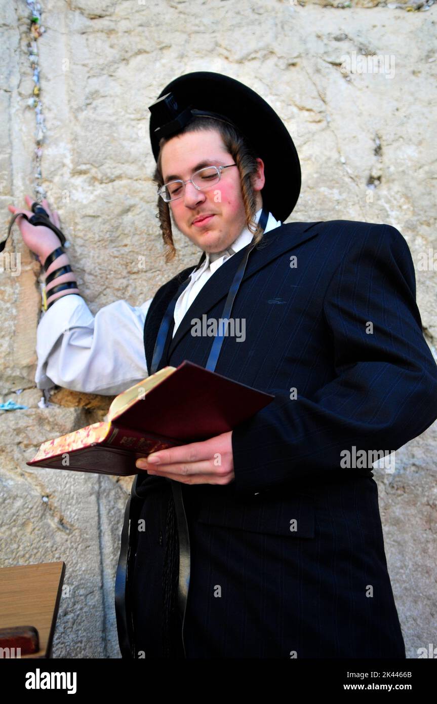 Jewish men praying by the Wailing Wall / Western Wall in the Jewish quarter in the old city of Jerusalem, Israel. Stock Photo