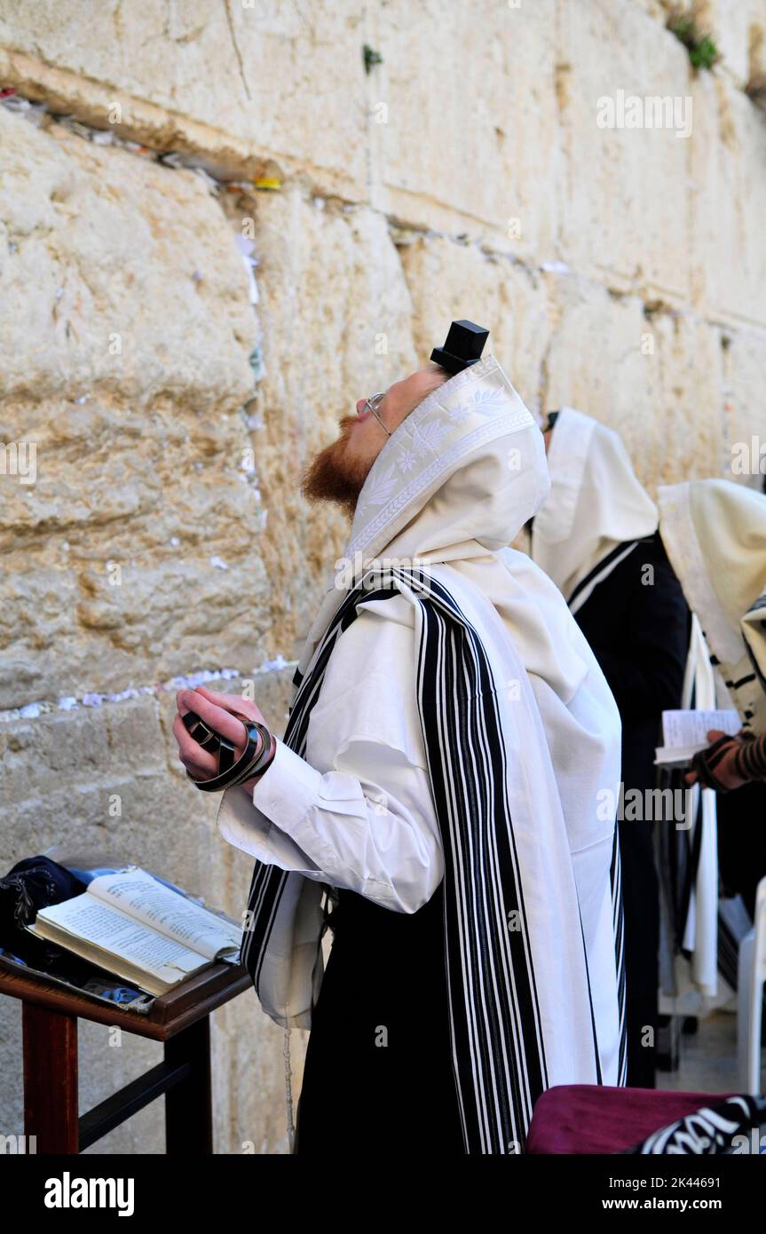 Jewish men praying by the Wailing Wall / Western Wall in the Jewish quarter in the old city of Jerusalem, Israel. Stock Photo