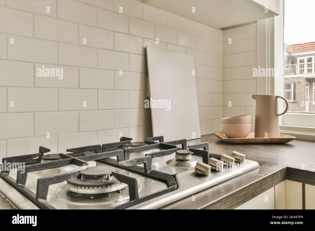 Interior of light kitchen with steel hood over stove apartment and appliances Stock Photo