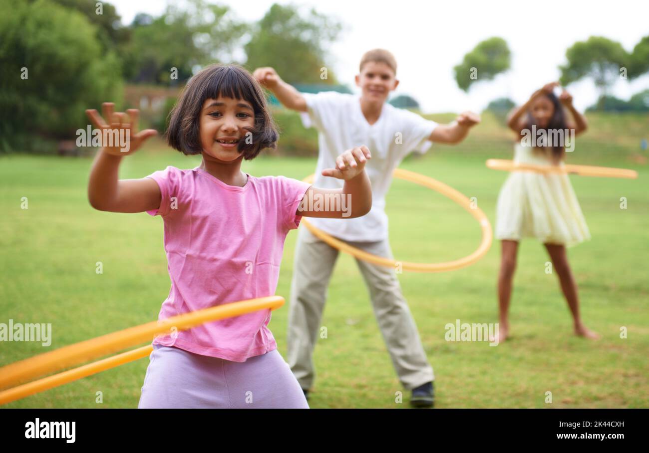 Having fun with hula-hoops. Three children playing with hula hoops outside. Stock Photo
