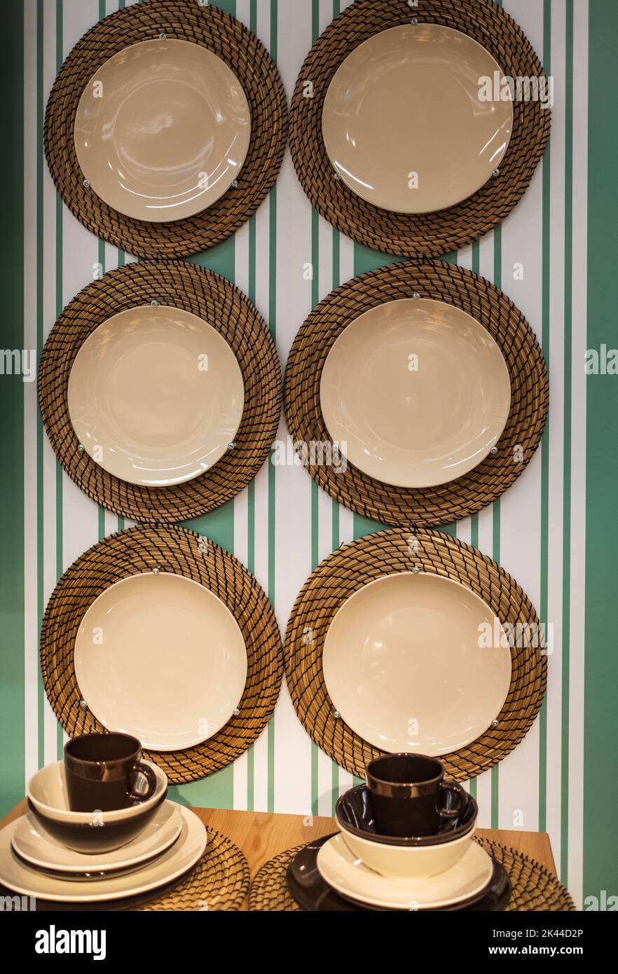 Interior of stylish kitchen with hanging plates on green wall. Hanging