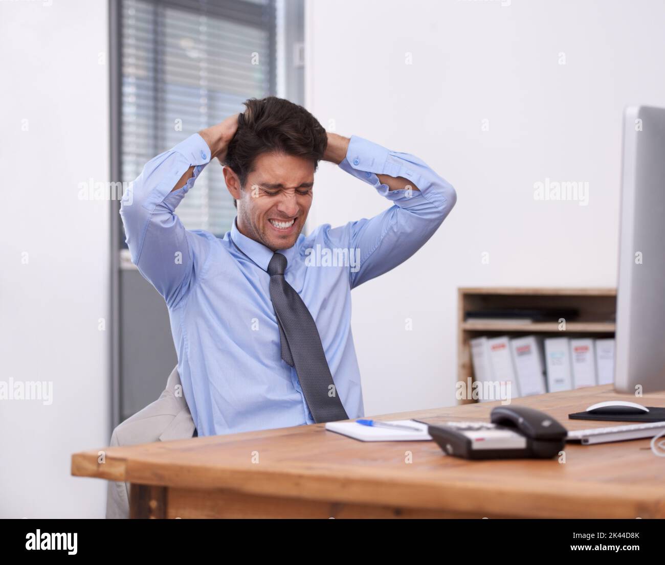 Aah, I cant this anymore. A stressed out businessman sitting at his desk and looking frustrated. Stock Photo