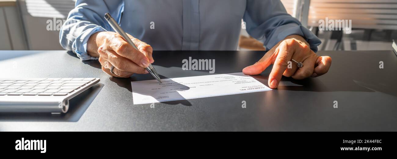 Writing Cheque. Signing Paycheck Or Money Check Stock Photo
