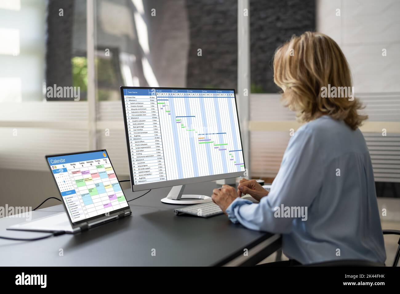 Employee Working On Calendar Schedule And Staff Time Sheet Stock Photo