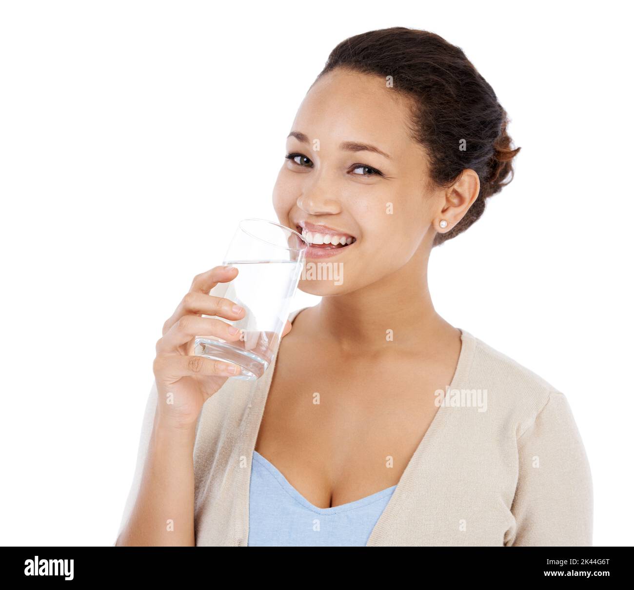 Getting some water to quench her thirst. Young woman smiling while drinking a glass of water