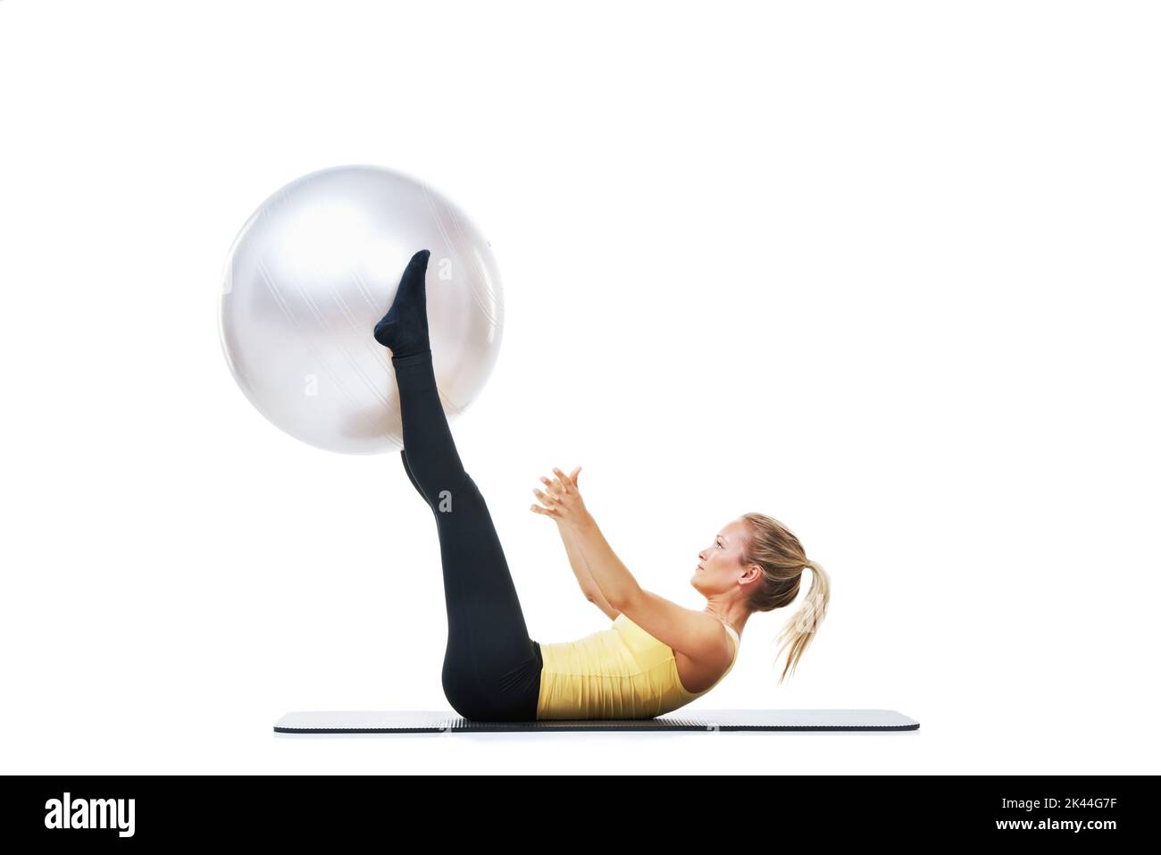 Working on toning my stomach. a female lifting an exercise ball up with her legs. Stock Photo