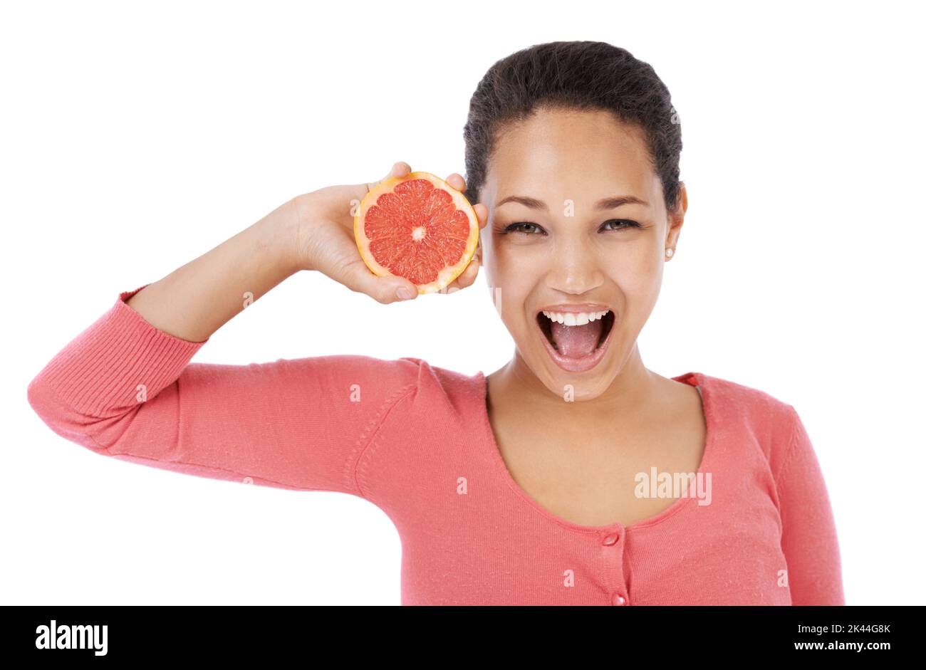 The best diet fruit. Young woman smiling while holding up a grapefruit