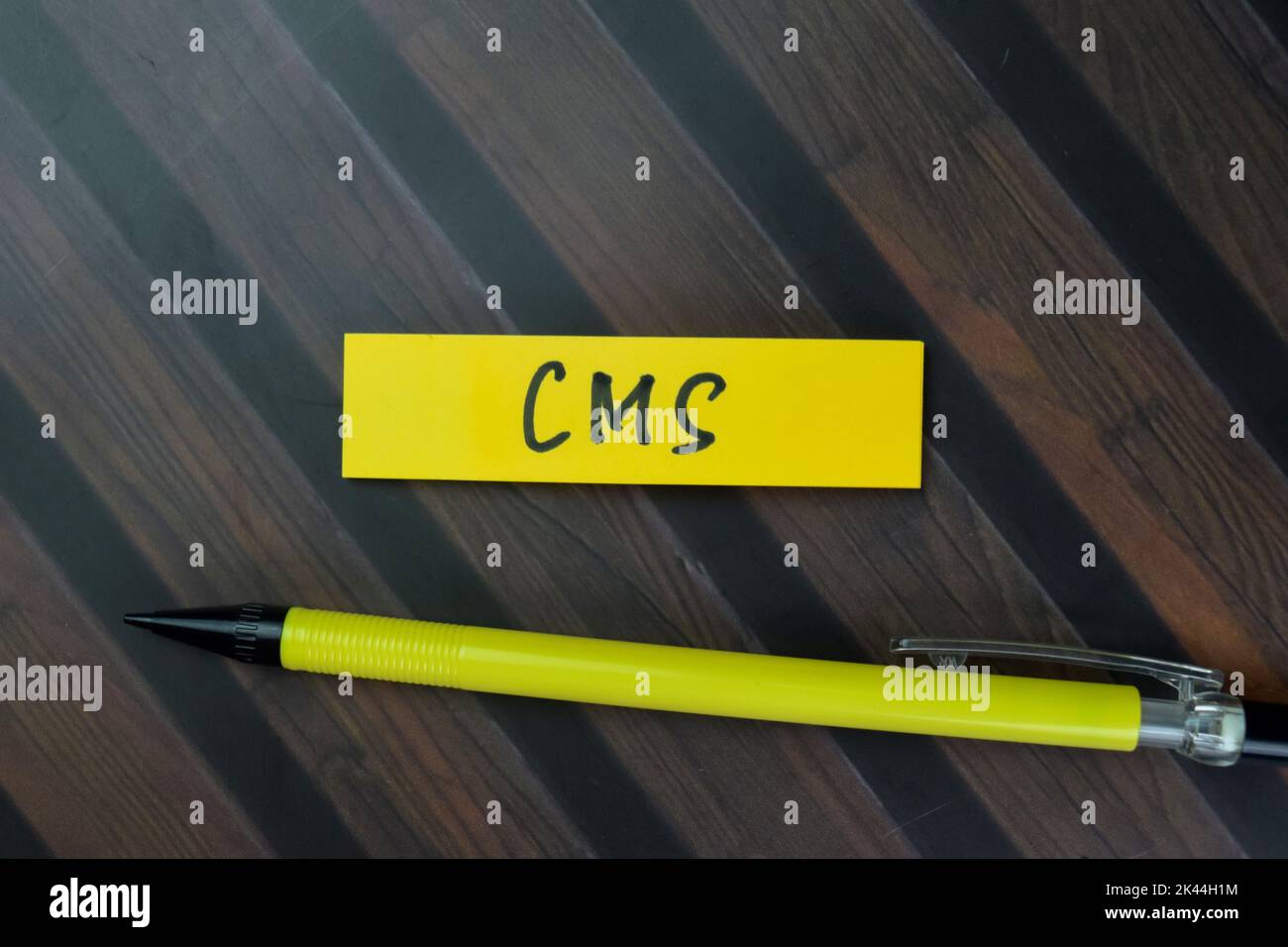 Concept of CMS write on sticky notes isolated on Wooden Table. Stock Photo