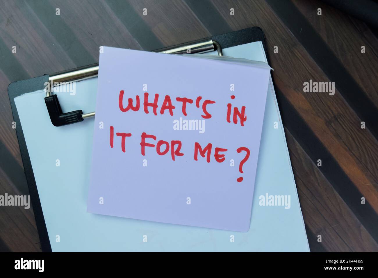 Concept of What's in it for me? write on sticky notes isolated on Wooden Table. Stock Photo