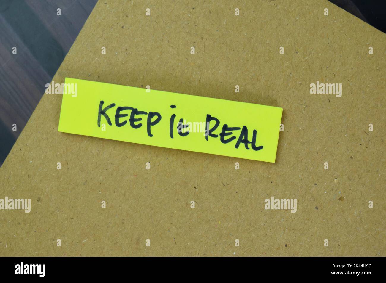 Concept of Keep it Real write on sticky notes isolated on Wooden Table. Stock Photo