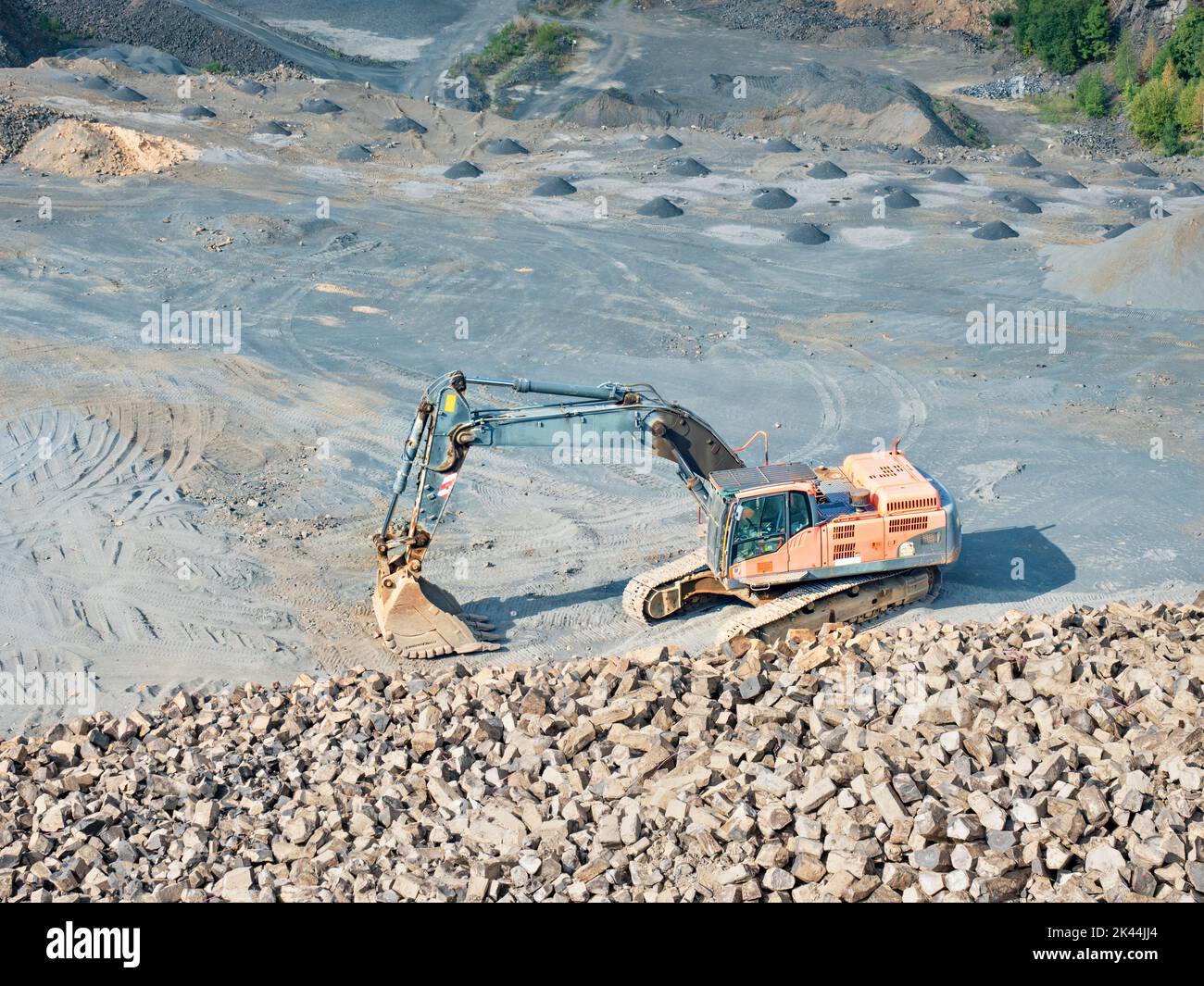 Old worn out loader between piles of crushed basalt stones. Mning