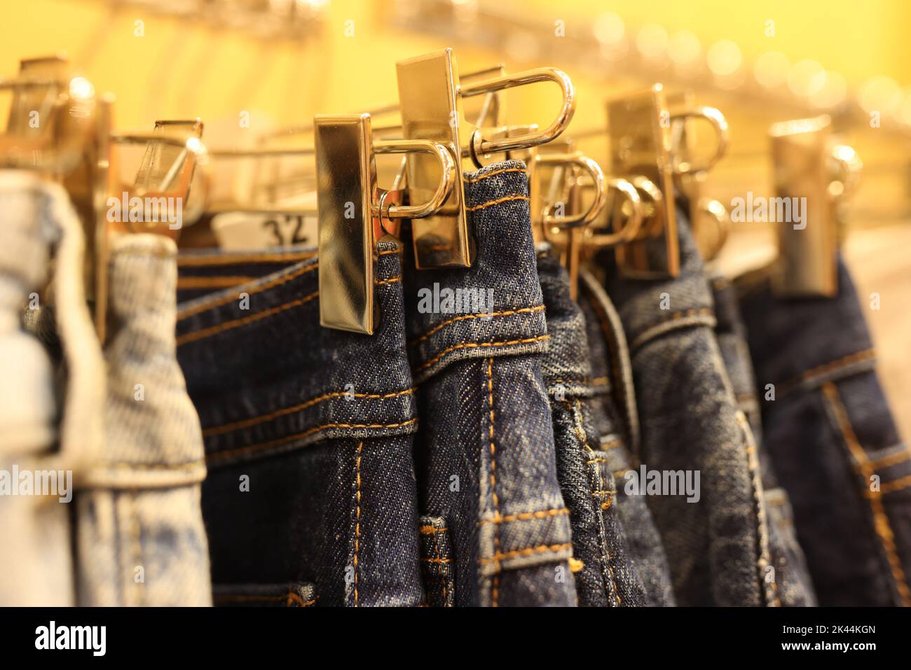 Denim shorts and pants hang on hangers in clothing store Stock Photo