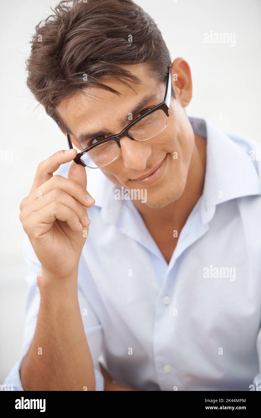 Business with a smile. An intelligent young man looking over the rim of