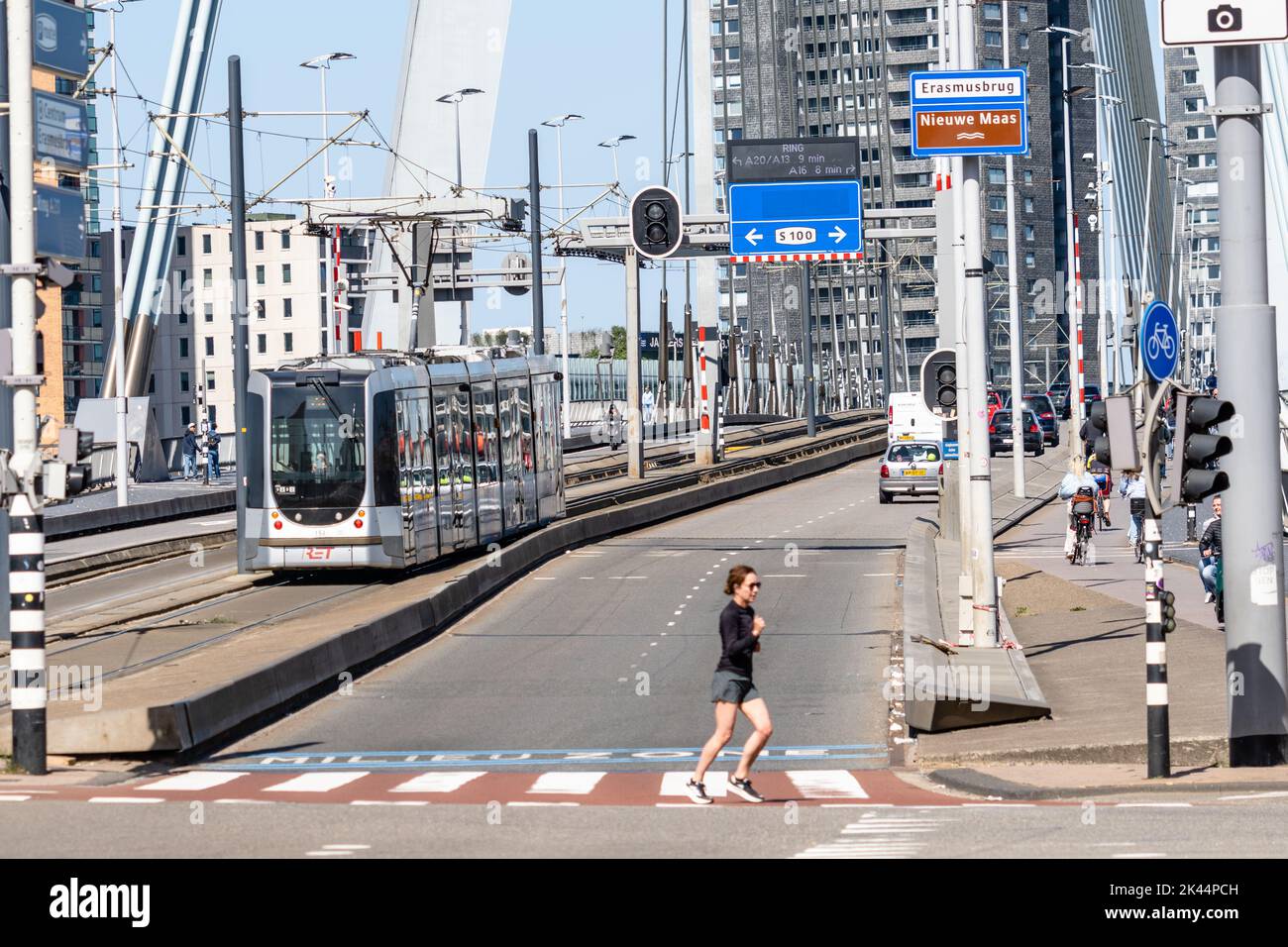 Rotterdam, Netherlands - May 8, 2022: People crossing and vehicles driving on the Erasmusbrug bridge over New Meuse river. Sunny day of spring Stock Photo
