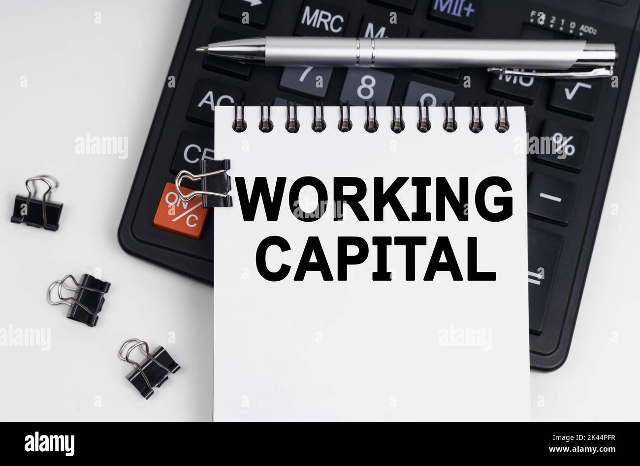 Business and economics concept. On the table is a calculator, a pen and a notebook with the inscription - WORKING CAPITAL Stock Photo