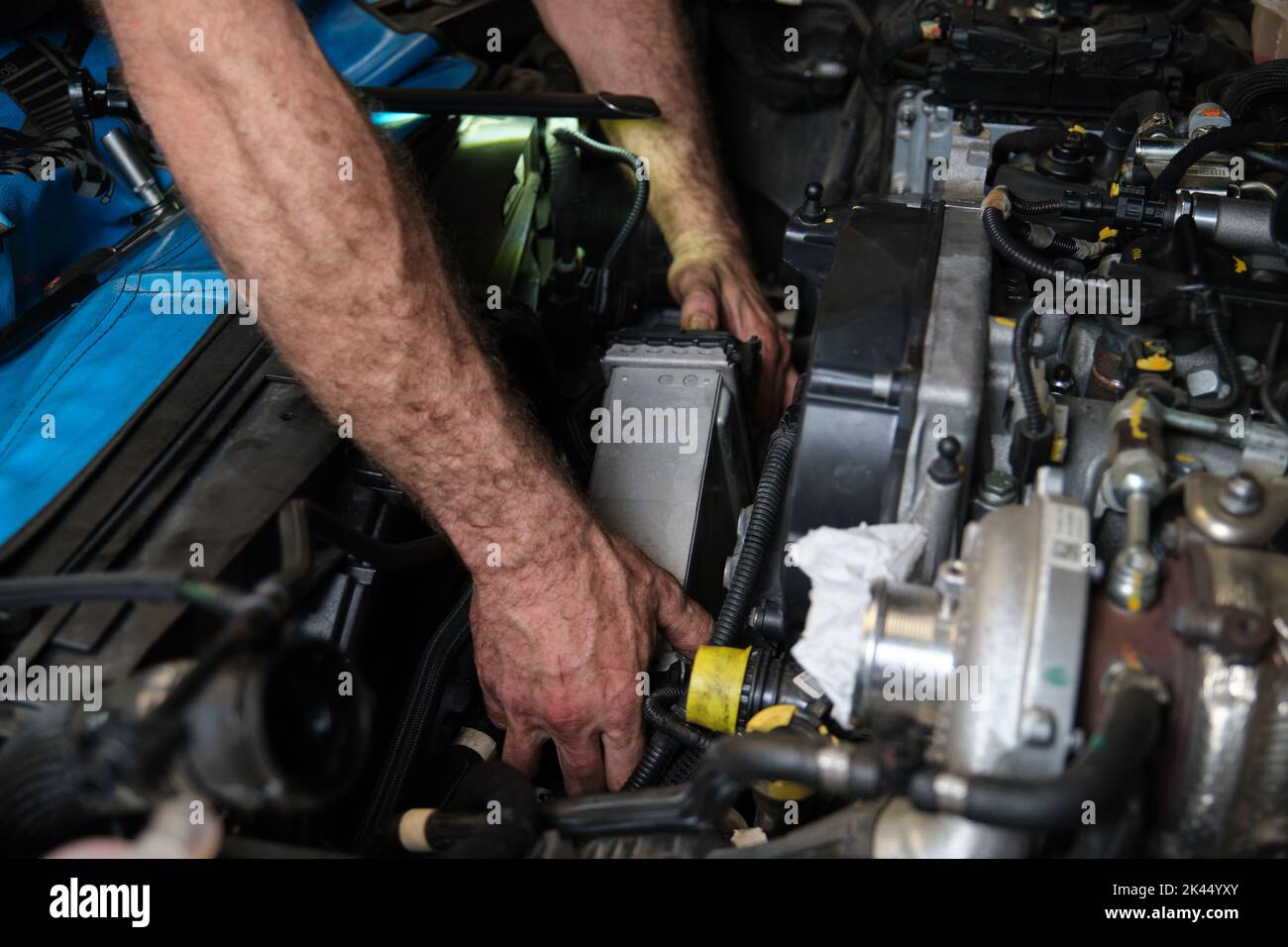 Car mechanic hands replacing intercooler on a car engine. Stock Photo