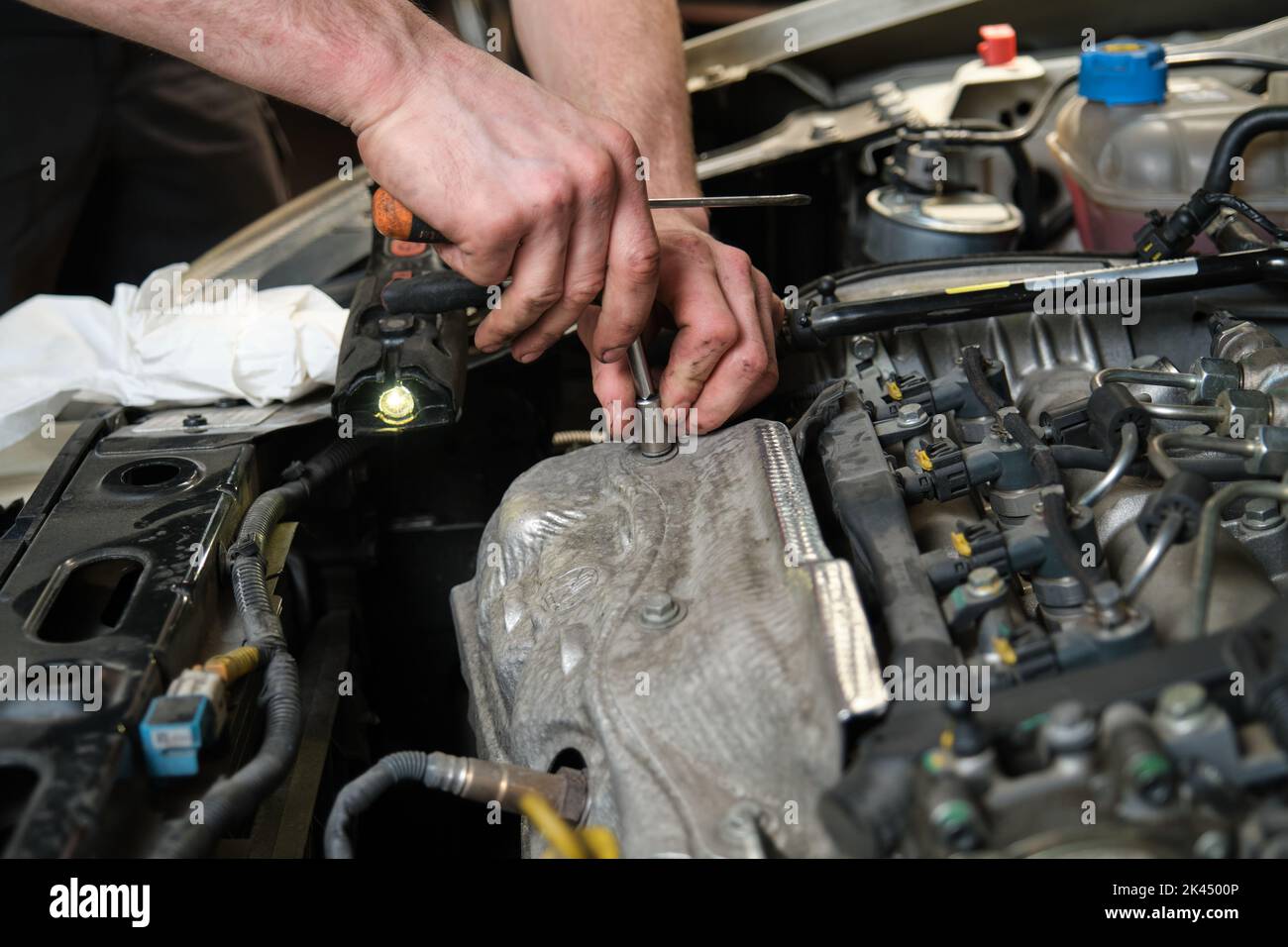 Close up of car mechanic hands doing car service and maintenance. Stock Photo