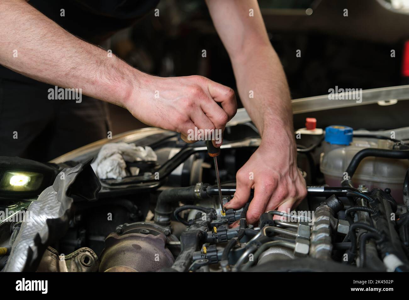 Technician removing fuel injectors checking dust and test pressure. Stock Photo