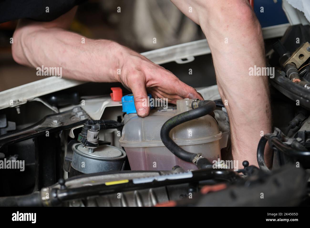 Car mechanic checking pulley on a car engine. Stock Photo