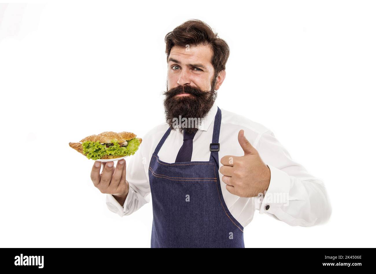 Traditional french croissant. Man bearded waiter wear apron carry plate with dish. Delicious croissant. Cafe concept. Guy serving croissant stuffed Stock Photo
