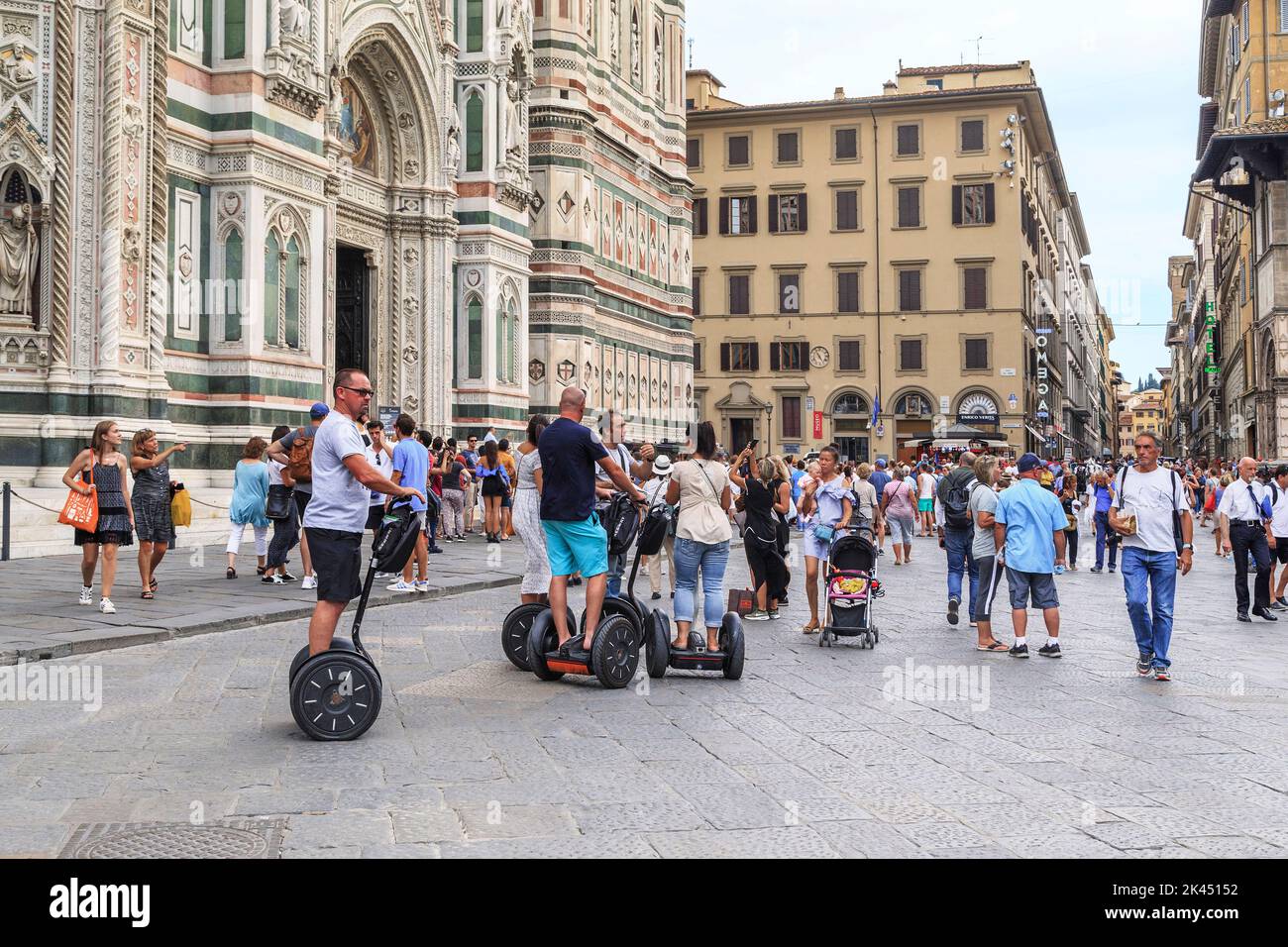 FLORENCE, ITALY - SEPTEMBER 12, 2018: These are unidentified tourist on the segway in a mobile tour near the Cathedral of the city. Stock Photo