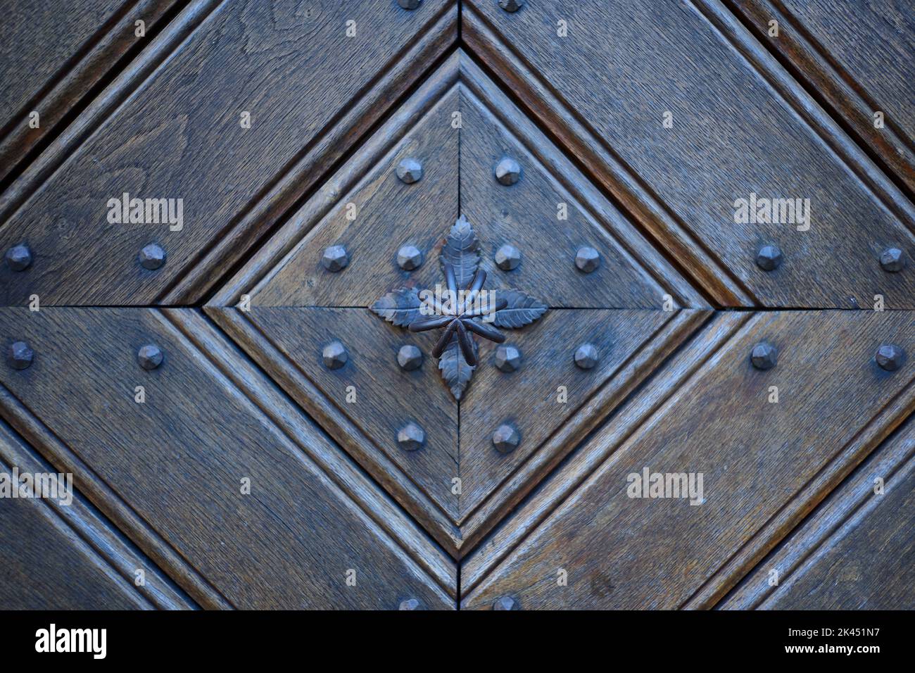 Detail of an old wooden door with traditional metal door knob. Detailausschnitt einer alten hölzernen Tür mit traditionellem  Türknauf aus Metall. Stock Photo