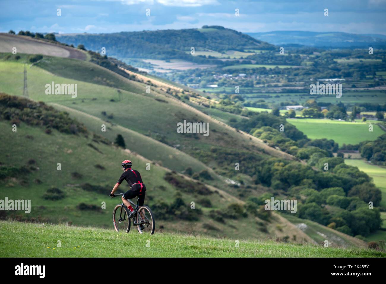 Brighton, September 29th 2022: A cyclist in the South Downs National Park at Devil's Dyke, overlooking the Fulking Escarpment and the Weald of Sussex as the season changes Stock Photo