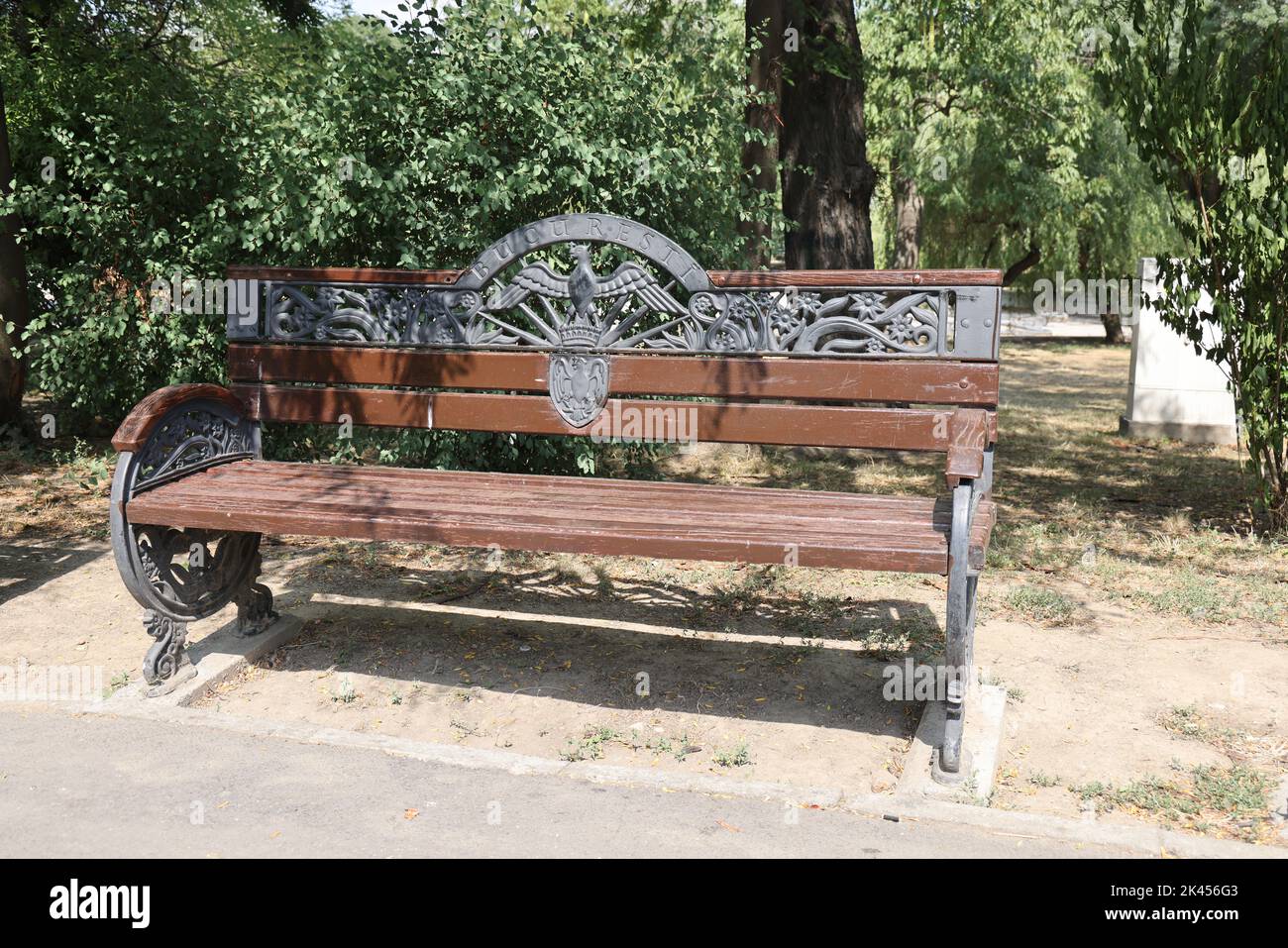 Historic wooden bench in Cișmigiu park, Bucharest, Romania with metal decoration including the Wallachian Eagle as the symbol of the city of Bucharest Stock Photo