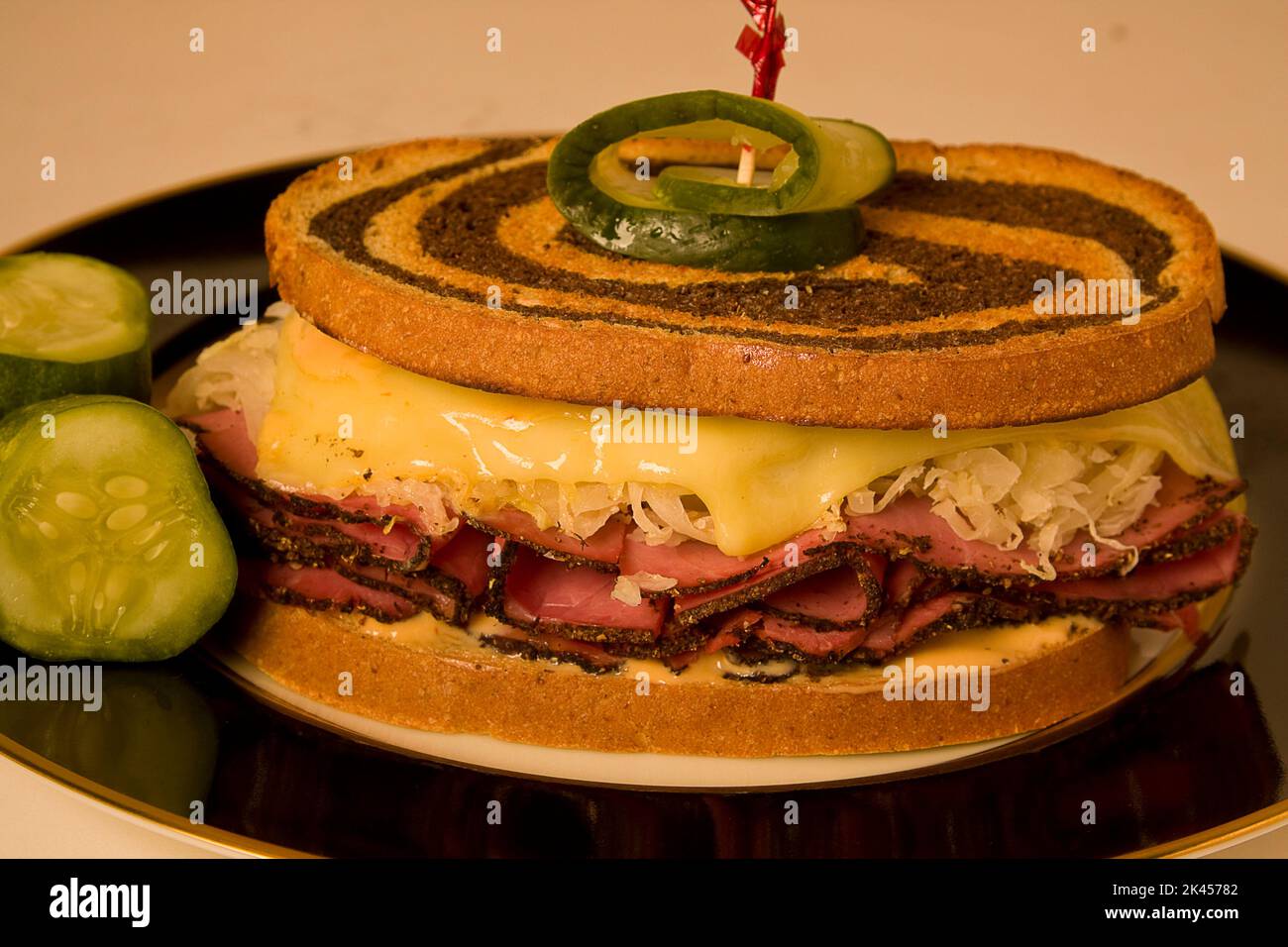 Full size reuben sandwich on a black plate with melted swiss cheese on