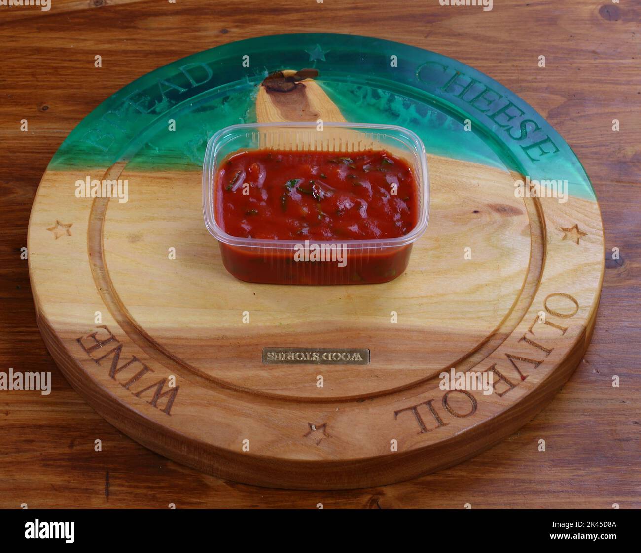 Ketchup on a wooden background in a plastic box Stock Photo