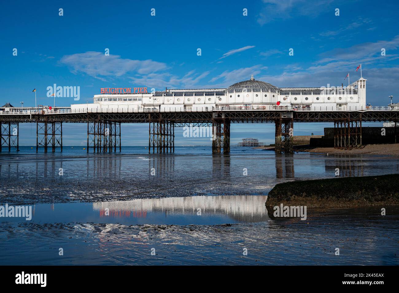 Brighton Palace Pier reflected in the sand on the beach in Autumn sunshine , Sussex , England UK  Photograph taken by Simon Dack Stock Photo
