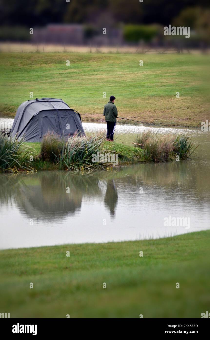 solitary man fishing on carp lake Stock Photo