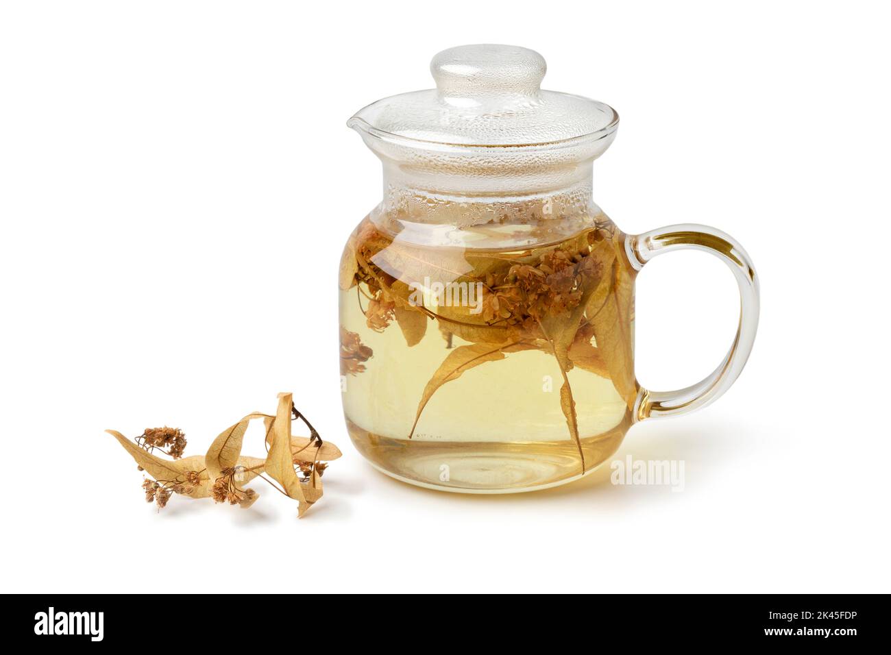 Glass teapot with dried tilia blossom close up isolated on white background Stock Photo