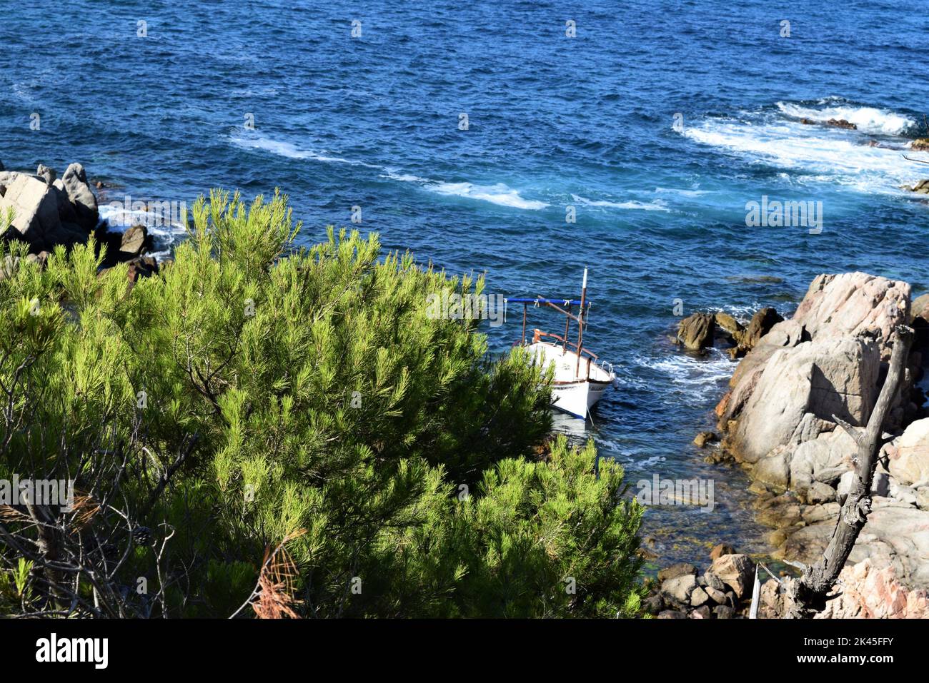 A Boat in a Small Bay on the Coast of the Mediterranean Sea on a Beautiful Sunny Day. Stock Photo