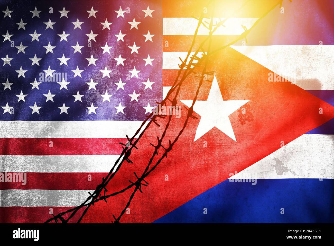 Grunge flags of USA and Cuba divided by barb wire sun haze illustration, concept of tense relations between USA and Cuba Stock Photo