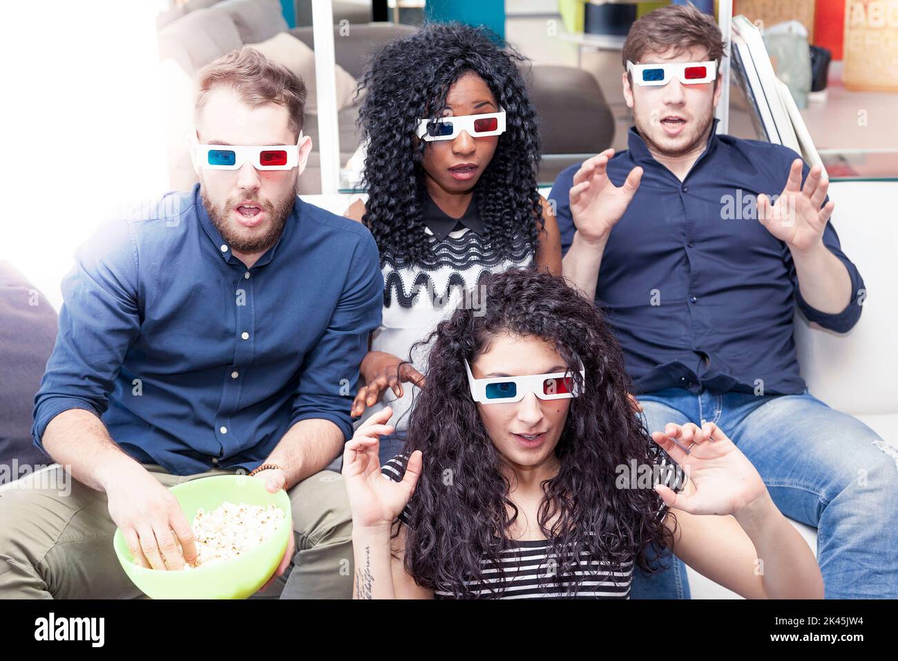 portrait of four young adults wearing 3d glasses at home Stock Photo
