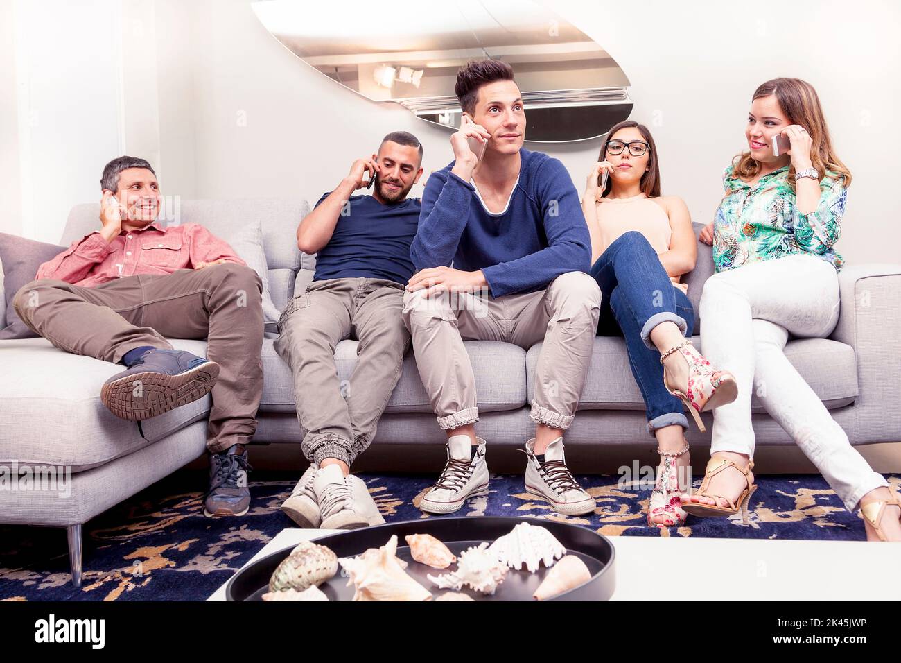group of friends on the couch to the phone at the same time Stock Photo
