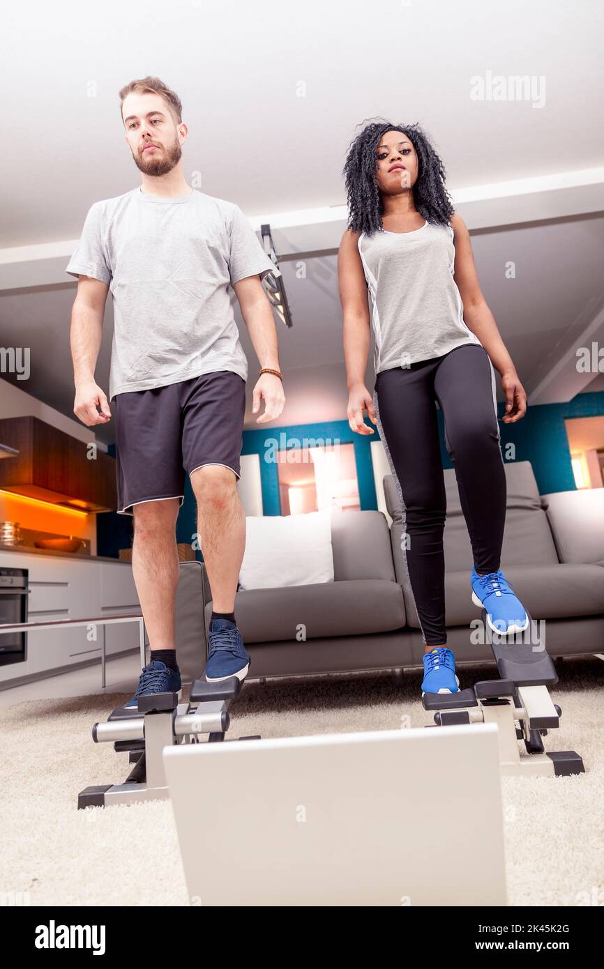 young couple he trains with the step machine at home Stock Photo