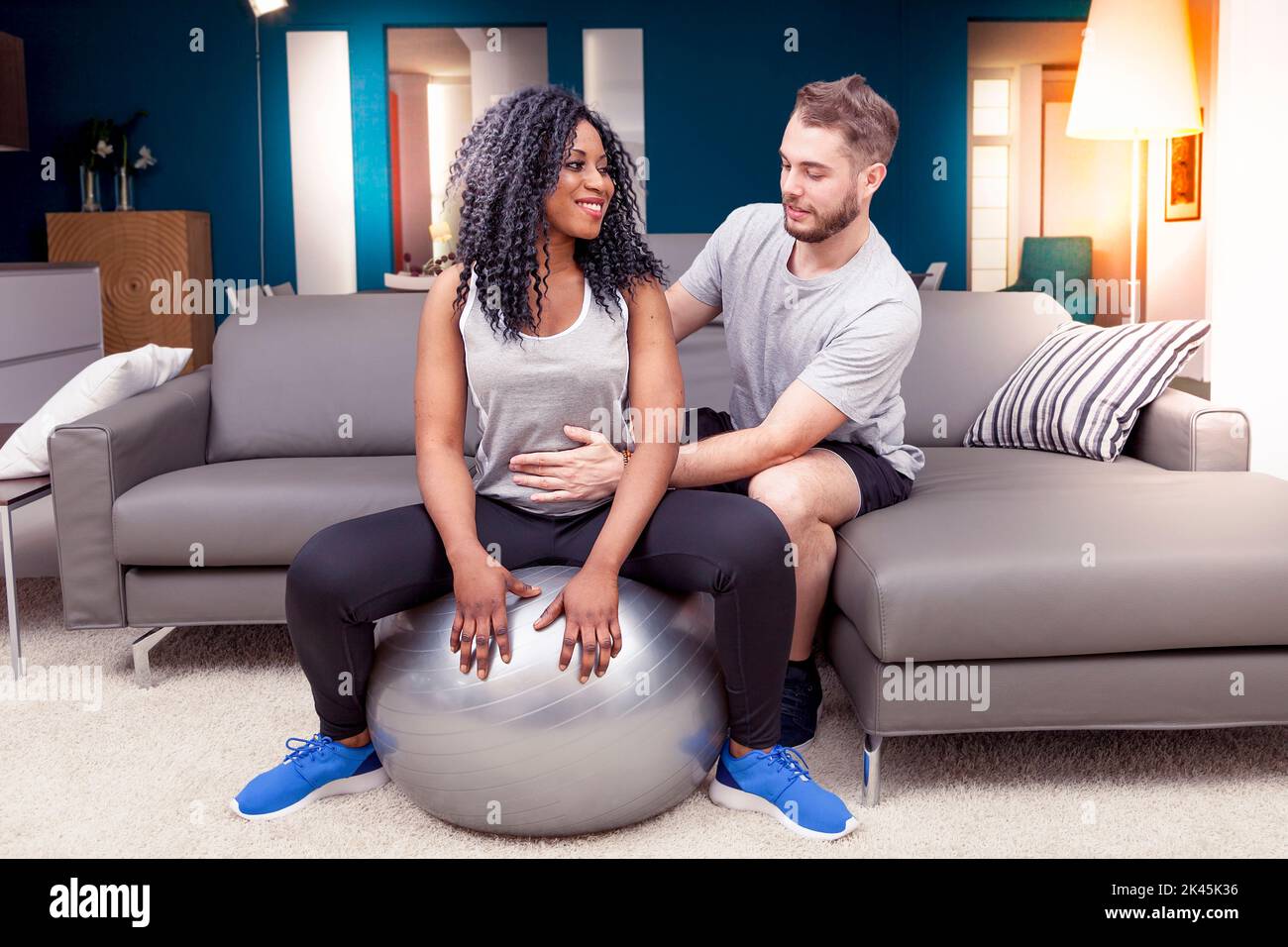 young couple are training doing gymnastics at home Stock Photo