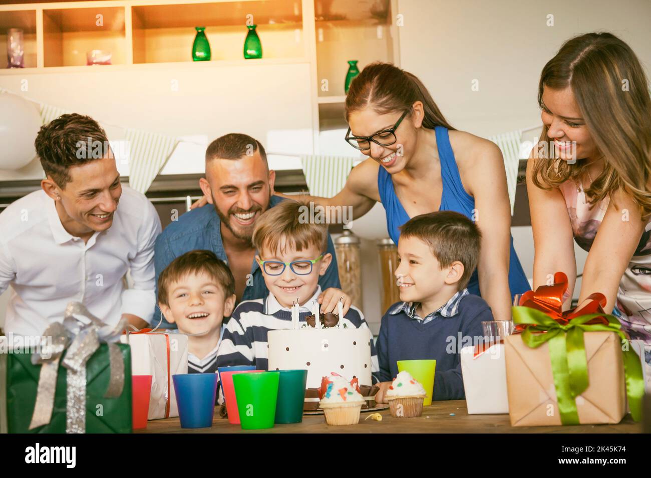 happy families with children celebrating around a cake for a birthday Stock Photo
