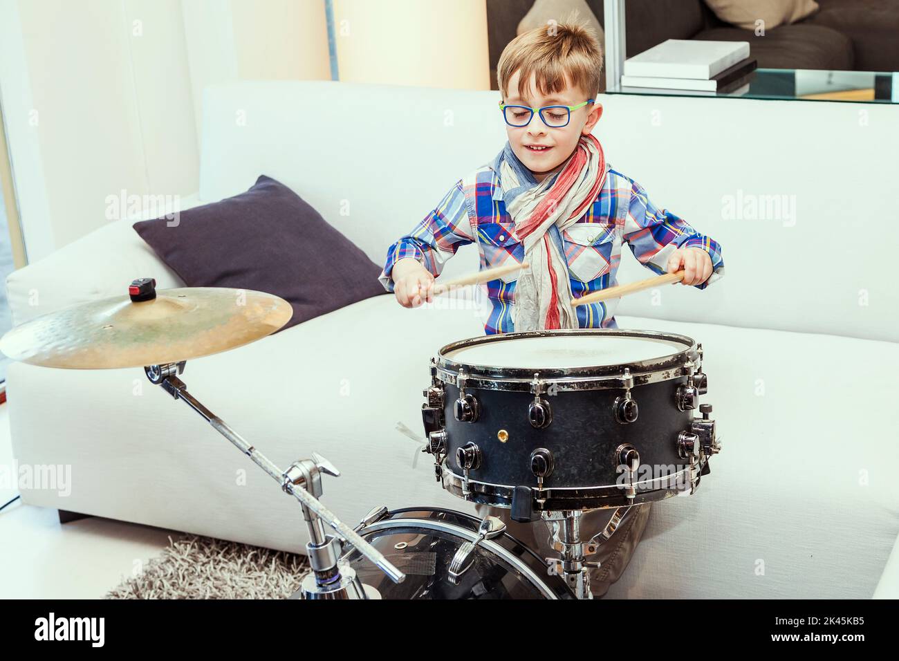 prodigy child plays the drums at home in his modern apartment Stock