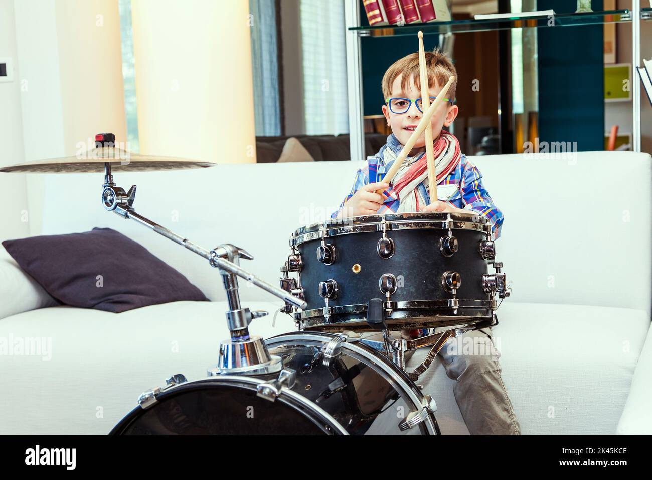 prodigy child plays the drums at home in his modern apartment Stock