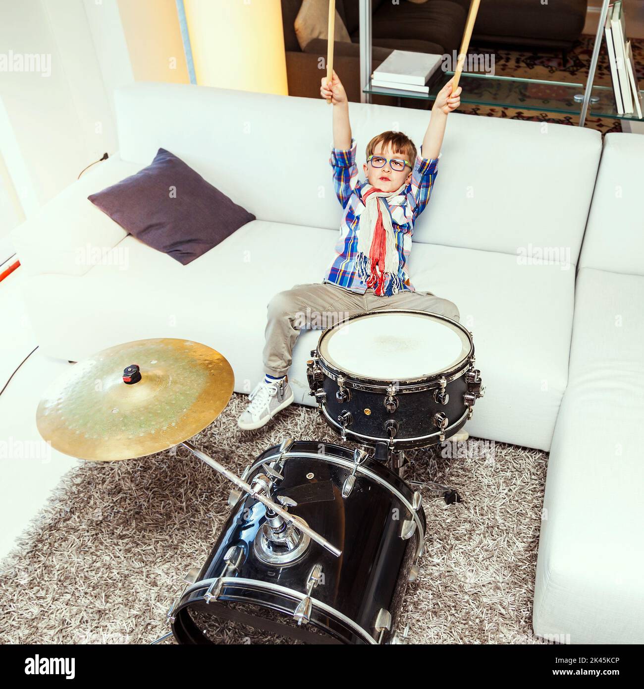 prodigy child plays the drums at home in his modern apartment Stock