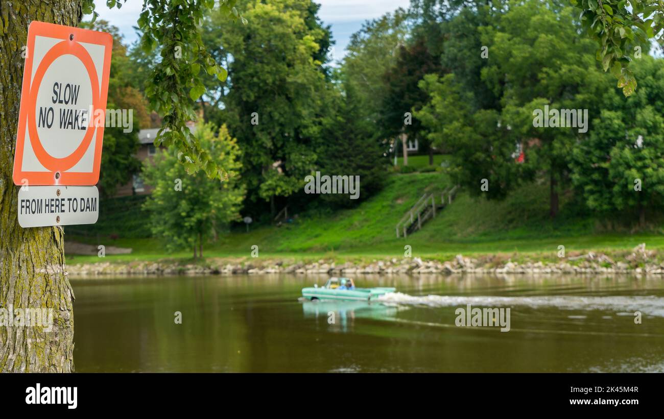 FRANKENMUTH, MI/USA - SEPTEMBER 8, 2018: An Amphicar 770 cars 'driving' in the Cass River past a 'No Wake' sign, Frankenmuth Auto Fest, Heritage Park. Stock Photo