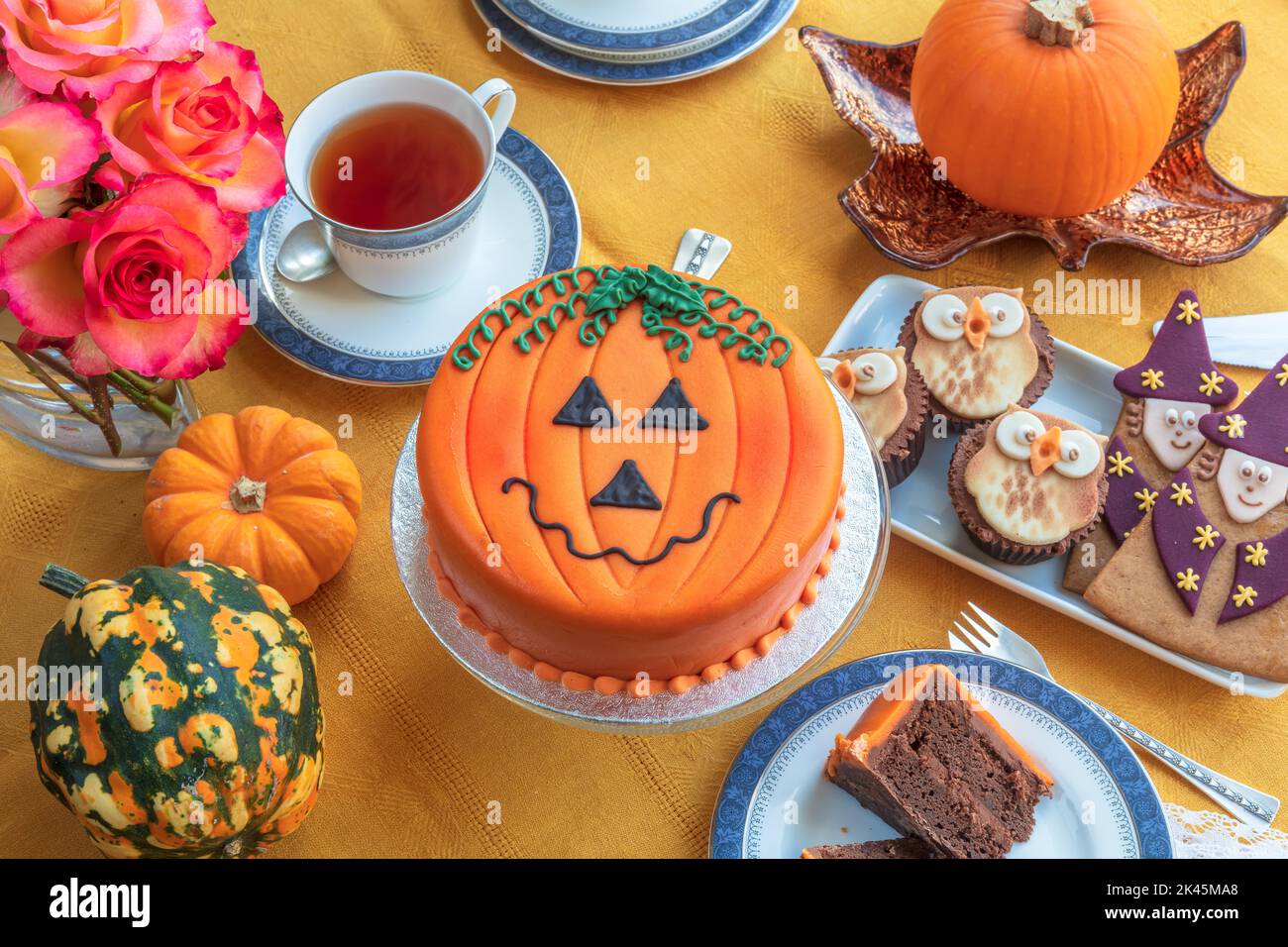Tea time table set with novelty cakes decorated in Halloween theme. Stock Photo